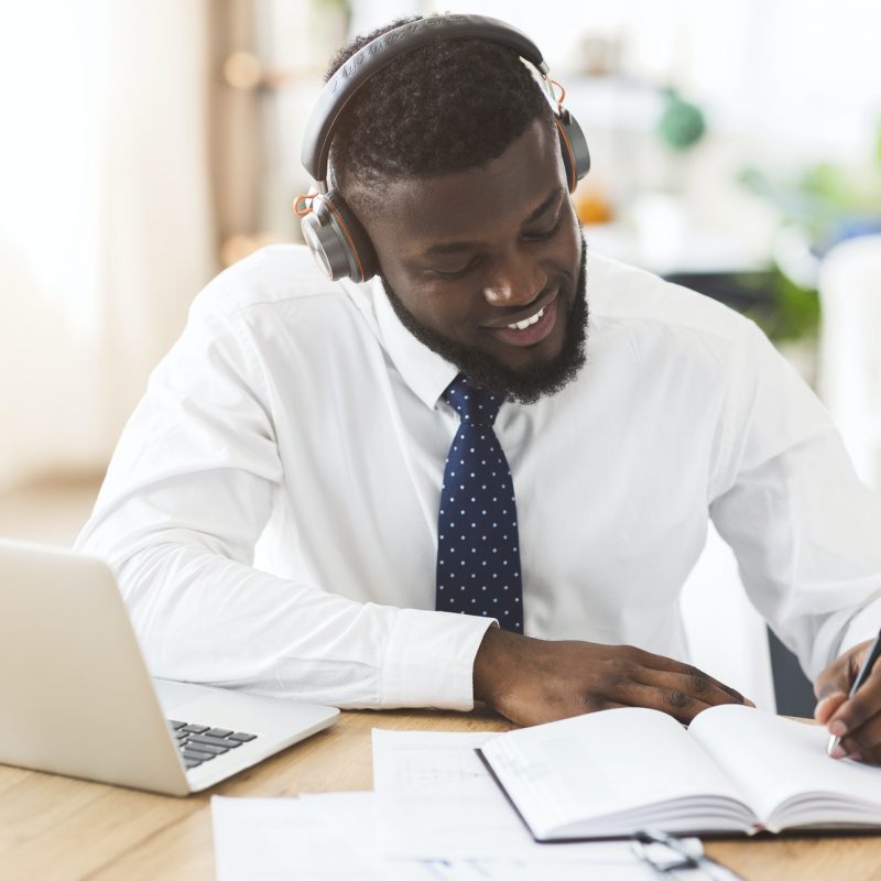 Creative businessman listening to music at workplace, planning future